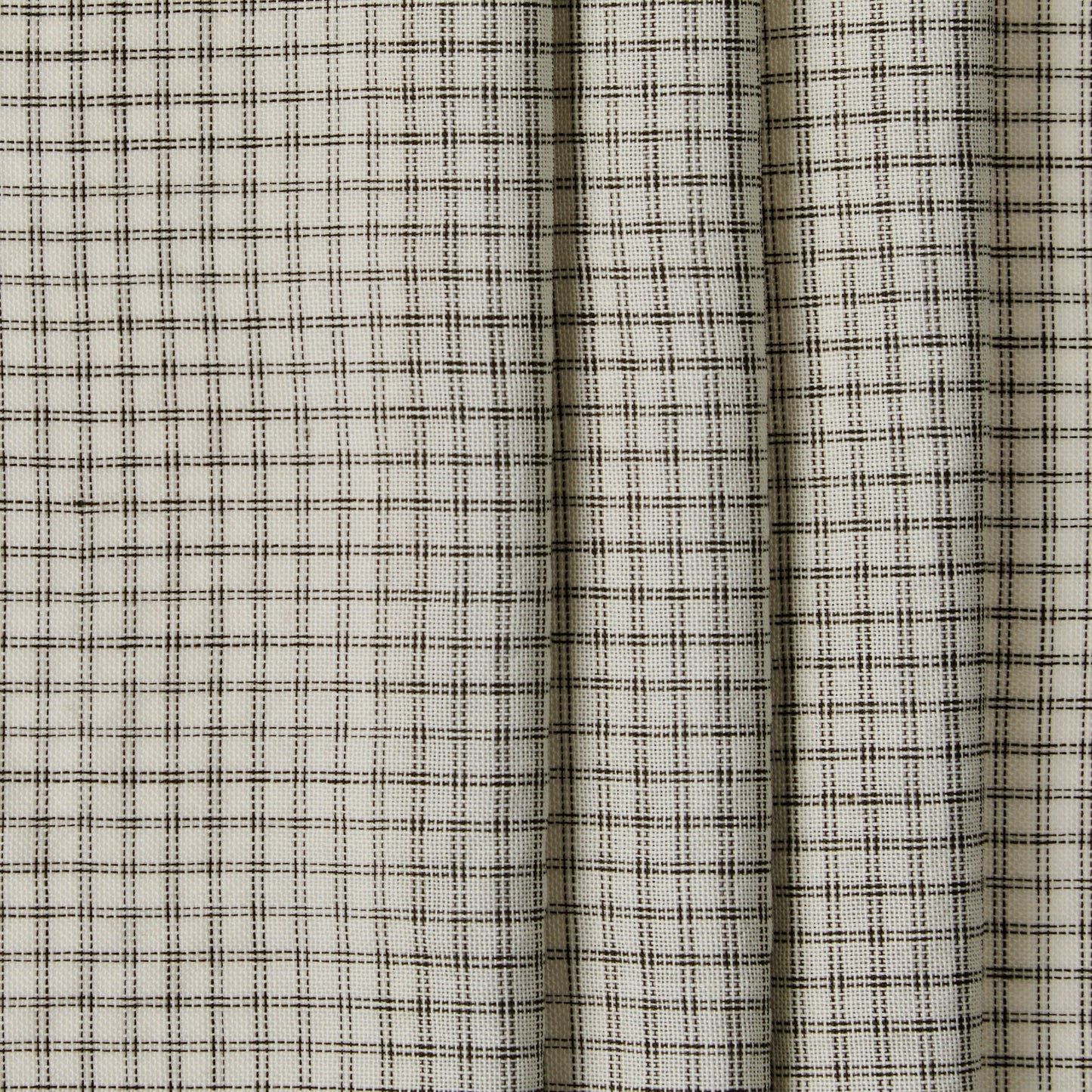 Close-up of a fabric with a subtle check pattern on a neutral background